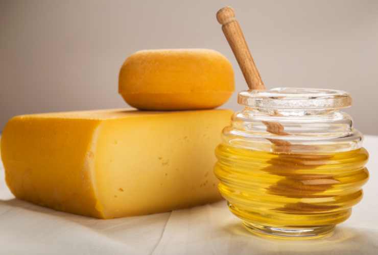 formaggi e ciotola con il miele