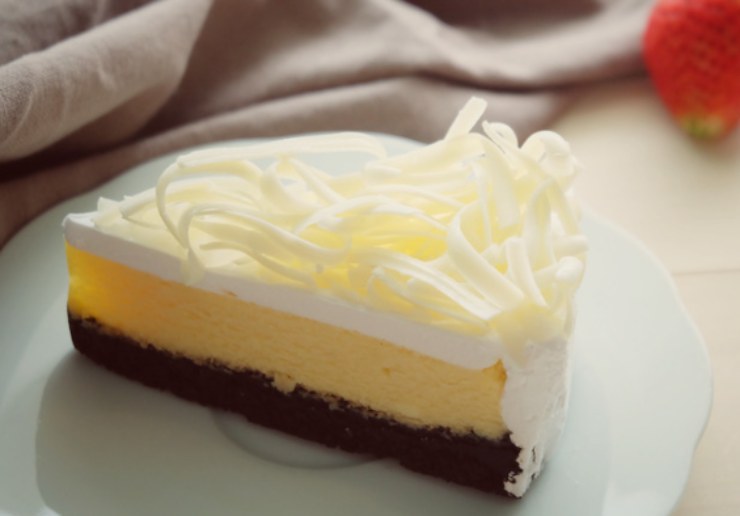 fetta di cheesecake al cioccolato bianco con base di biscotti al cacao