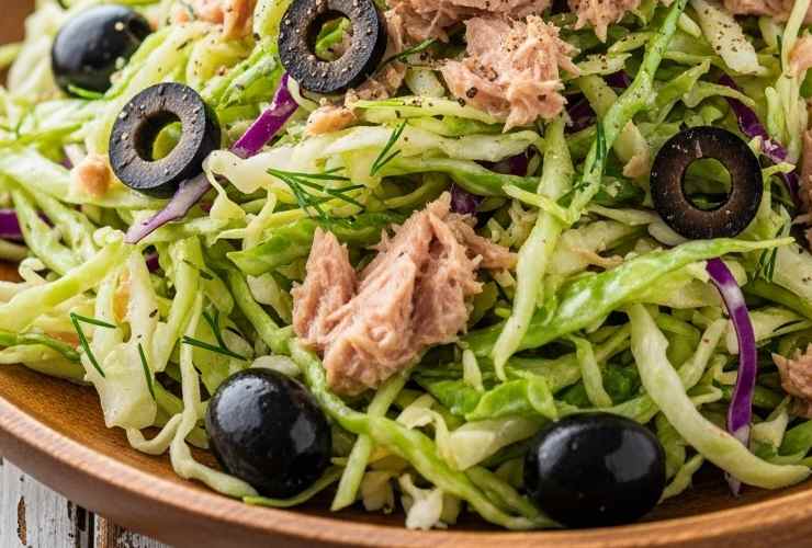 primo piano di insalata di verza con tonno e olive nere tagliate