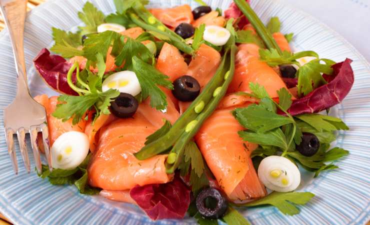 piatto di insalata con salmone affumicato, fagiolini, cipollotto e olive