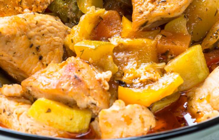 primi piano di pollo con patate e sugo di pomodoro