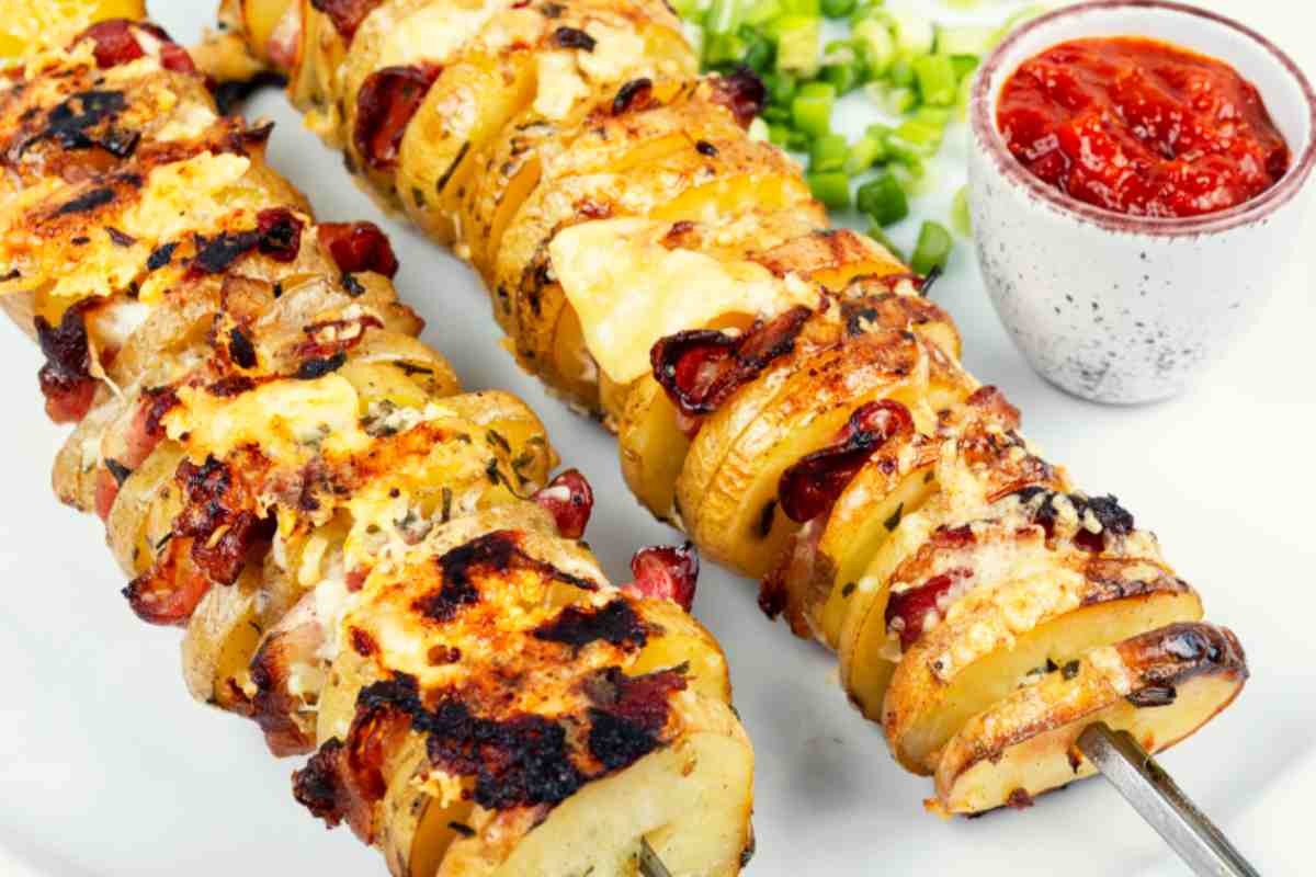 spiedini di patate dorate in un piatto con salsa di pomodoro