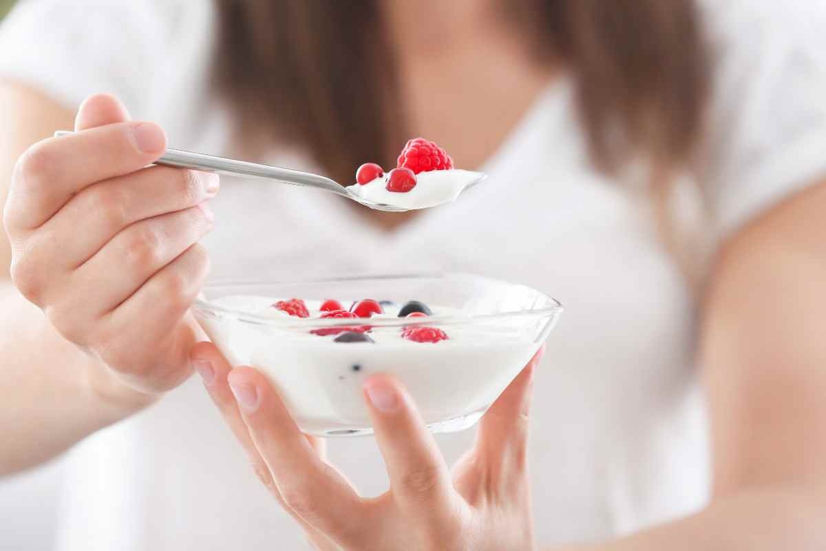 donna con un vasetto di yogurt