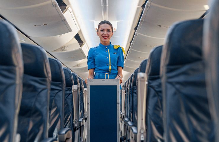 Una hostess con un carrello di cibi e bevande in aereo