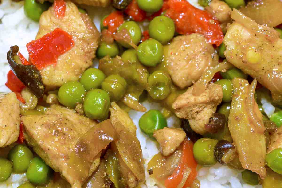 Piatto con bocconcini di pollo e piselli visto dall'alto