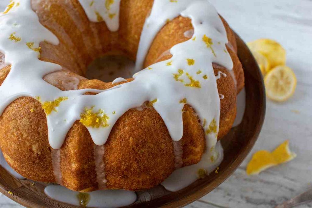 un ciambellone al limone coperto di glassa al cioccolato bianco su un vassoio