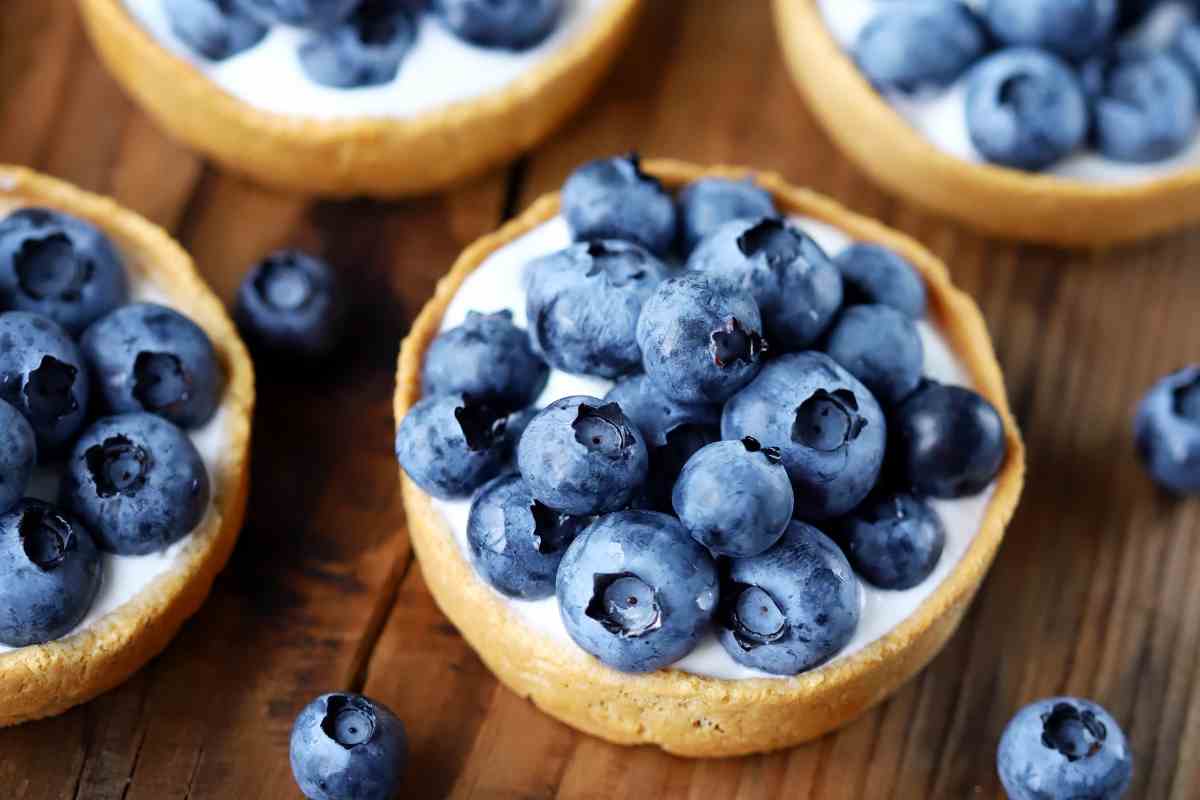 Crostatine ai mirtilli su un piano di legno viste dall'alto