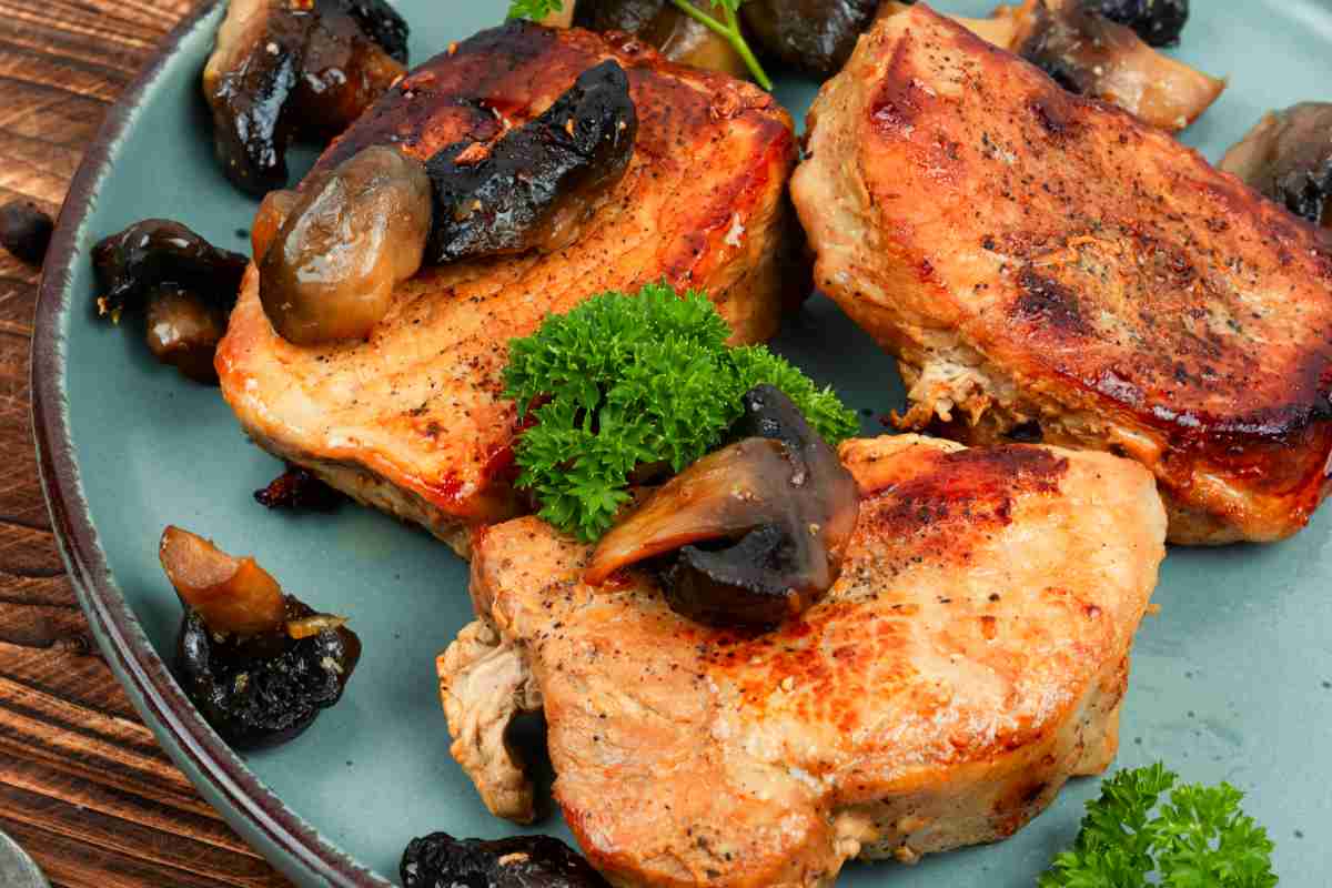 un piatto con dei medaglioni di maiale e funghi di contorno
