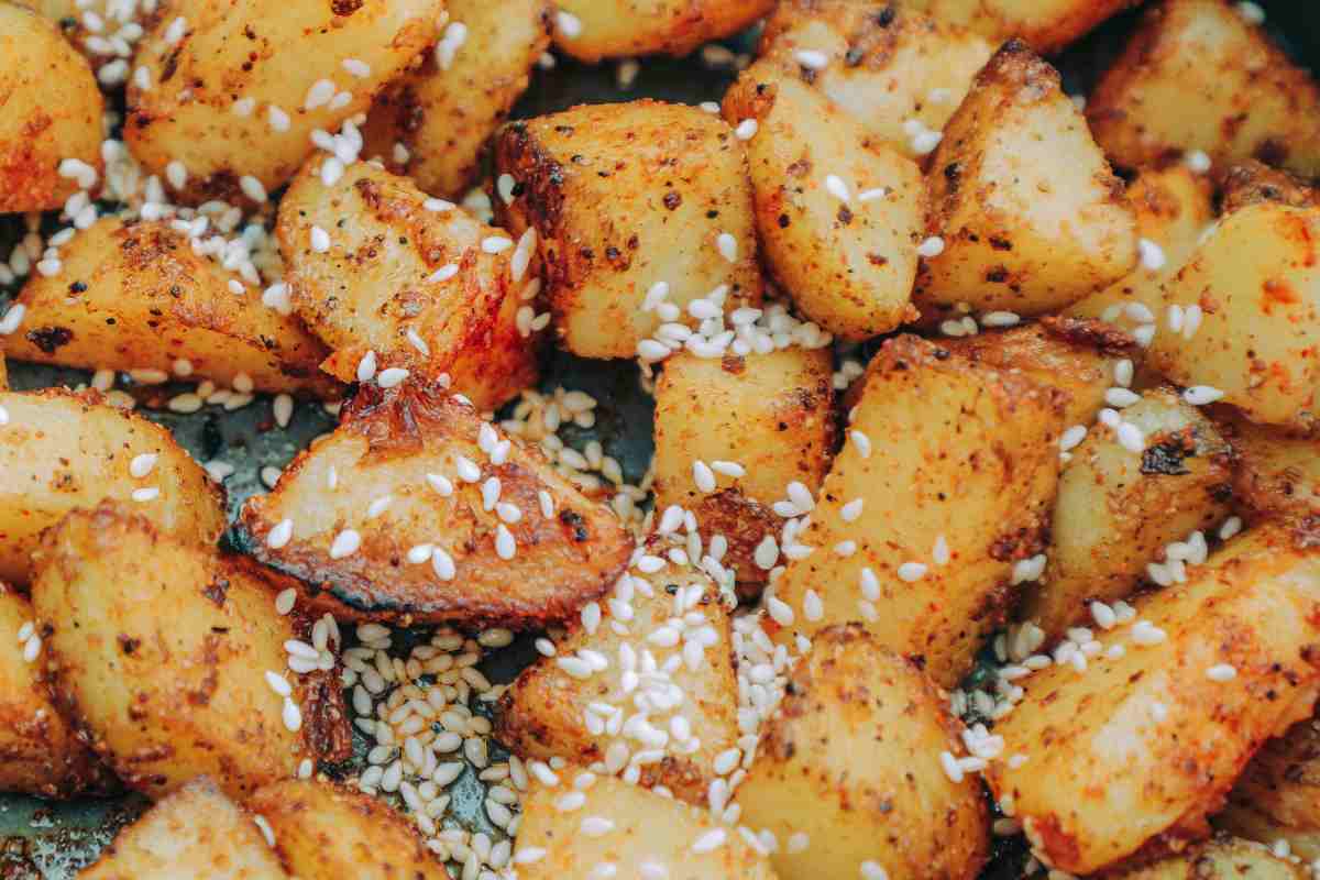Patate al forno con pangrattato e semi di sesamo in una teglia