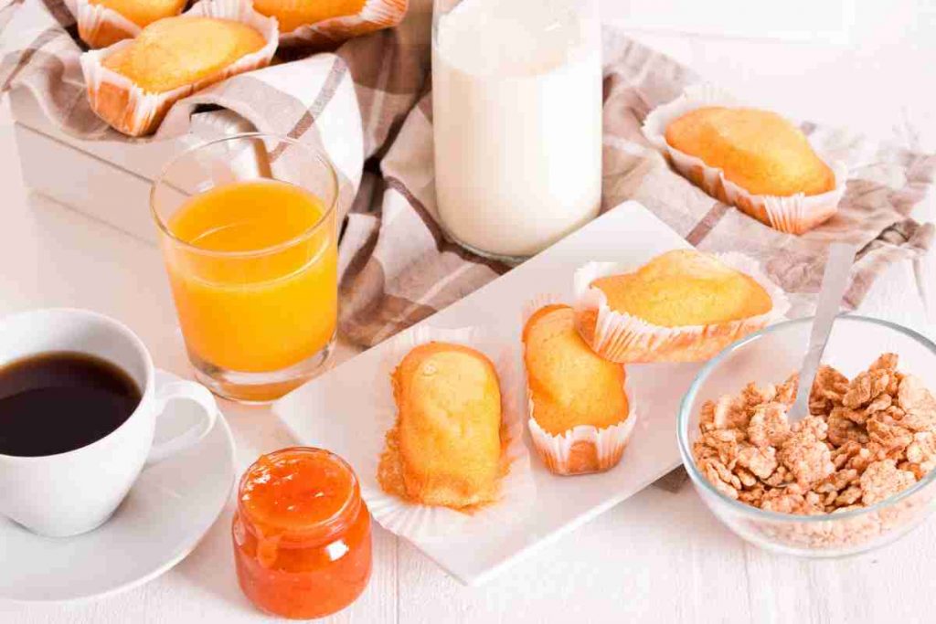 Colazione con latte, caffè e plumcake con panna e limone