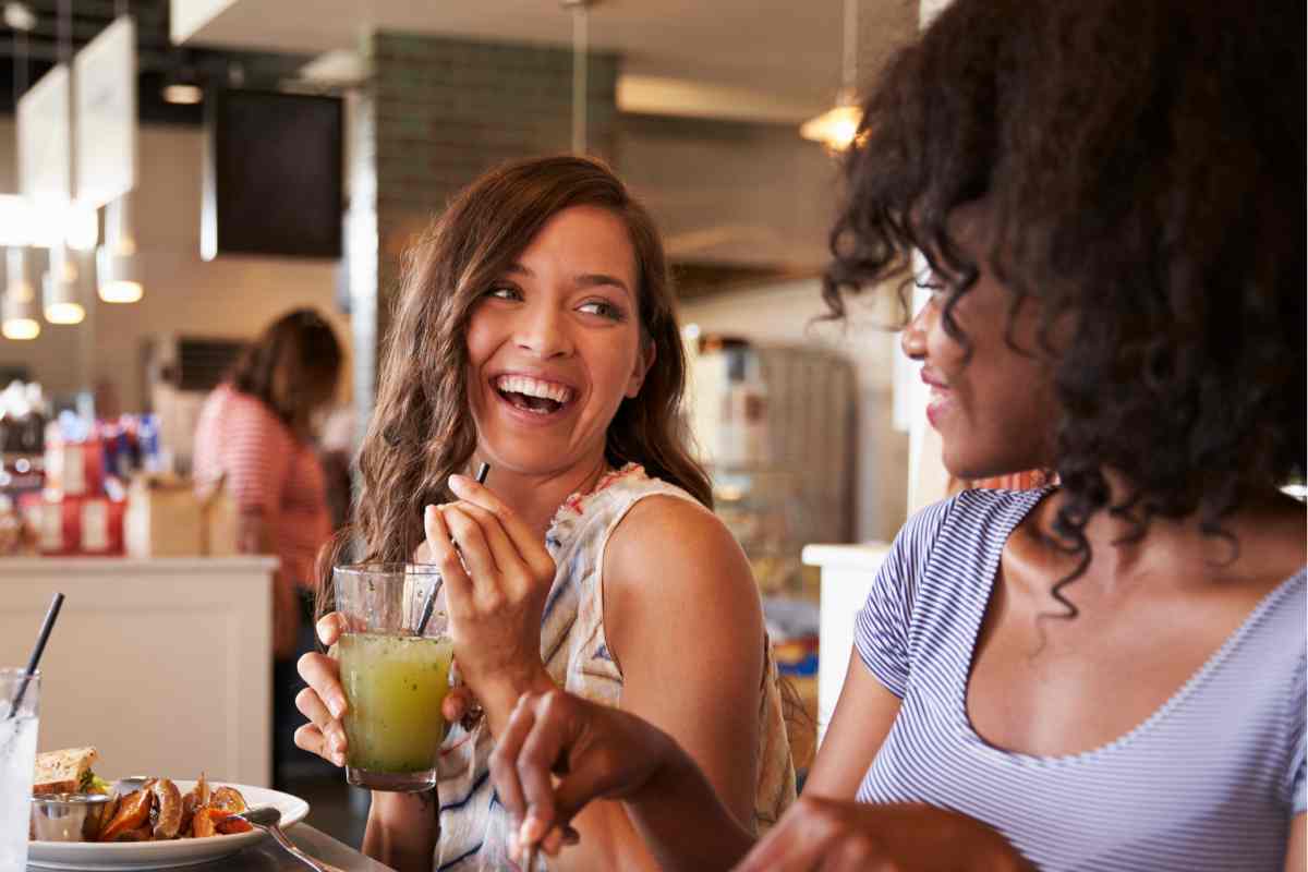 Due donne sorridenti che pranzano insieme