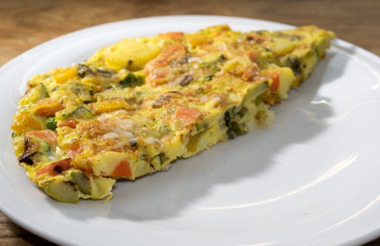 Una porzione di  frittata rustica al forno con verdure, formaggi e salumi avanzati