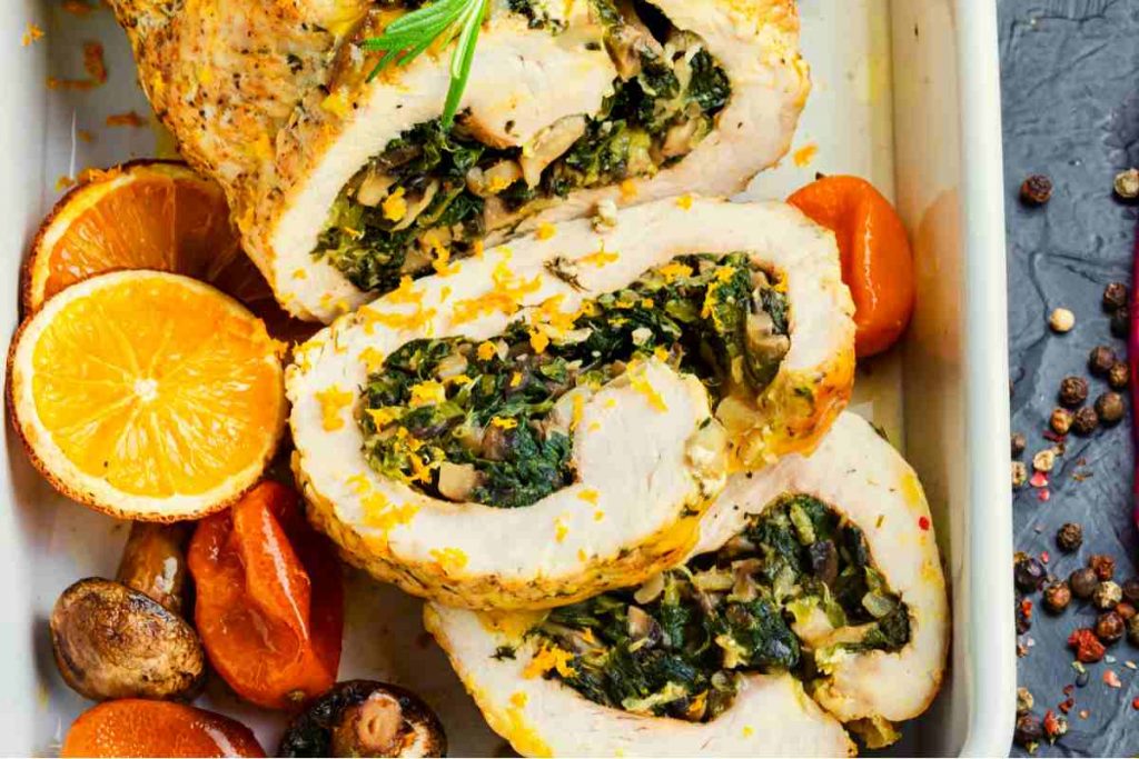 fette di Rollè di tacchino ripieno con olive e pistacchi in una pirofila