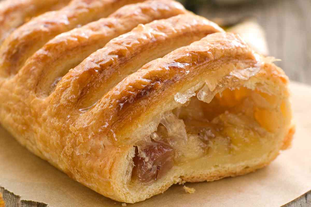uno strudel di pasta sfoglia ripieno di mele su un tavolo