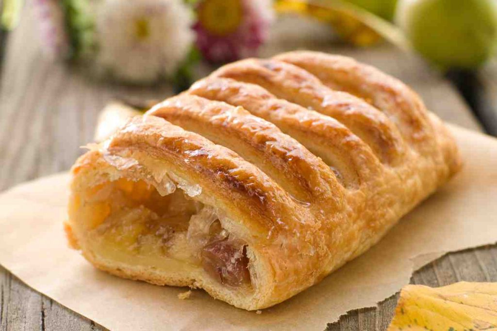 uno strudel di pasta sfoglia ripieno di mele su un tavolo