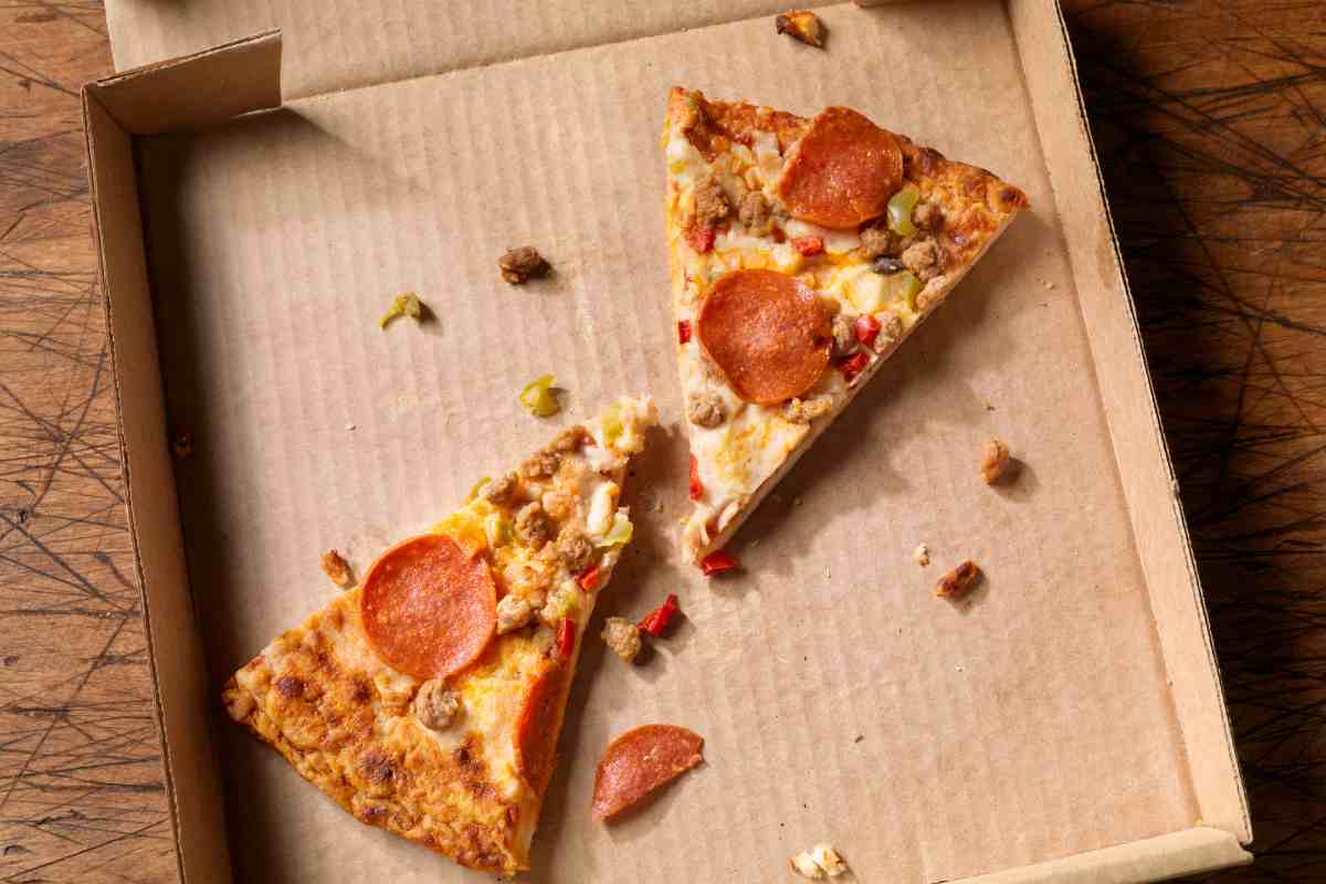 Due fette di pizza su un cartone