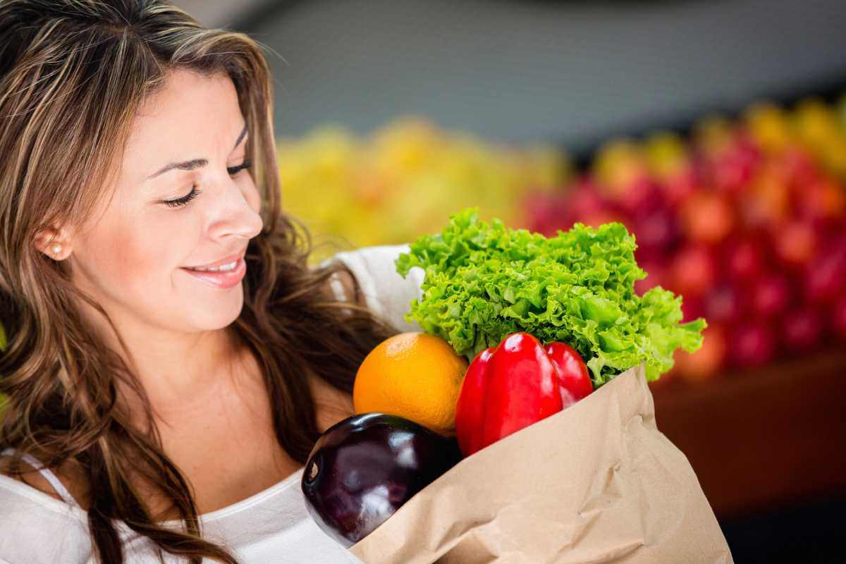 donna con busta di frutta e verdura in mano