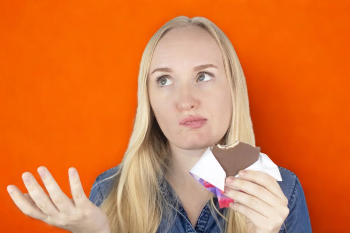 donna con aria perplessa che mancia del cioccolato