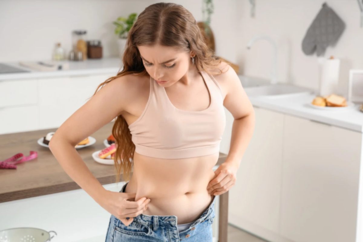 donna che si tocca i rotolini sul punto vita