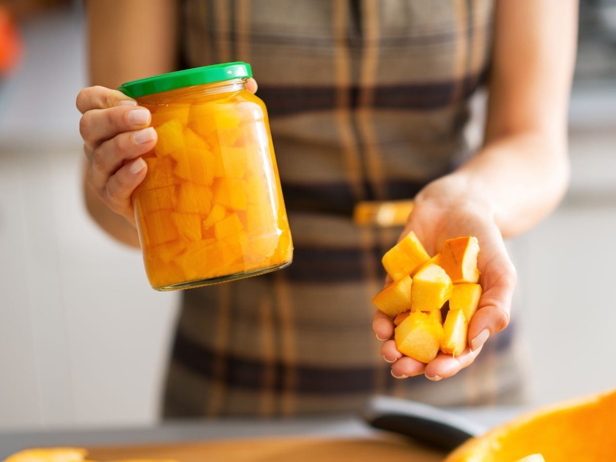 una donna tiene in mano un barattolo con zucca