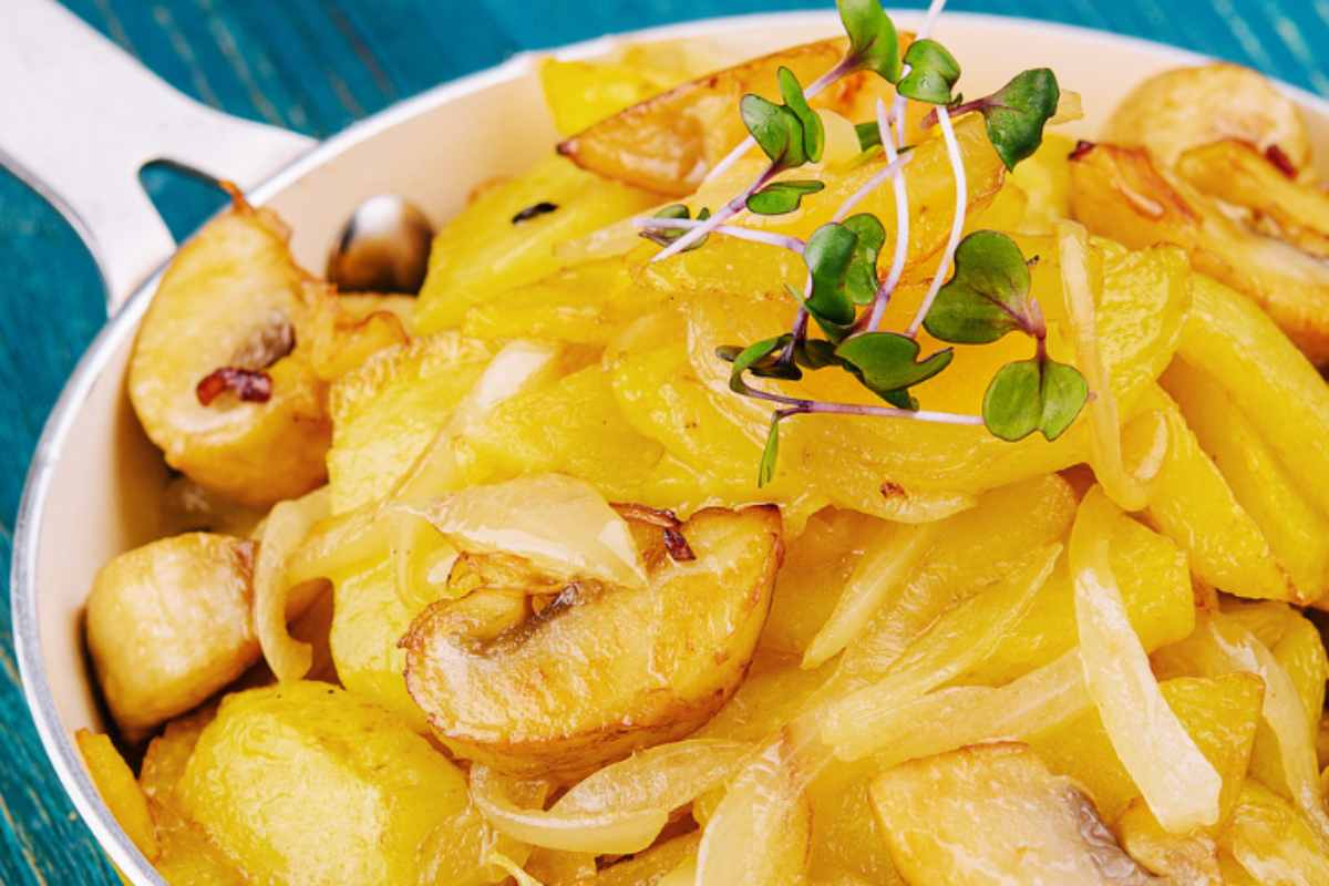 patate e cipolle in una padella con erbe aromatiche