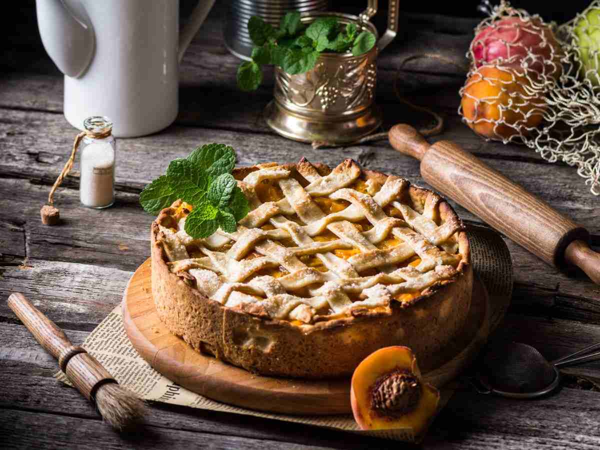 una crostata con delle pesche su un tagliere