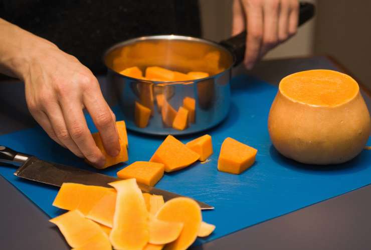 persona che mette i tocchetti di zucca nel pentolino