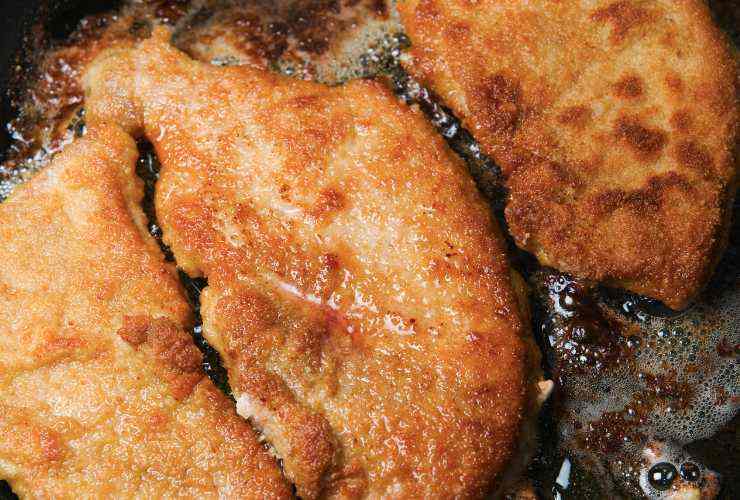 tre cotolette mentre si friggono nell'olio