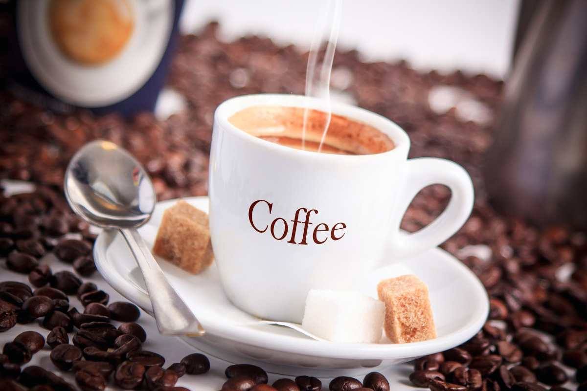 tazzina di caffè, con chicchi di caffe intorno