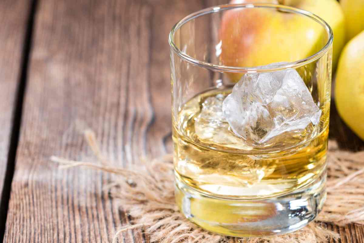 bicchiere con ghiaccio e mele sullo sfondo