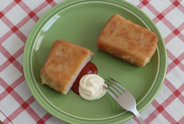 pezzi di mortadella panata in piatto verde