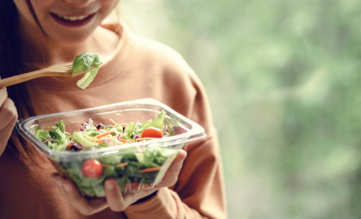 ragazza che mangia insalata
