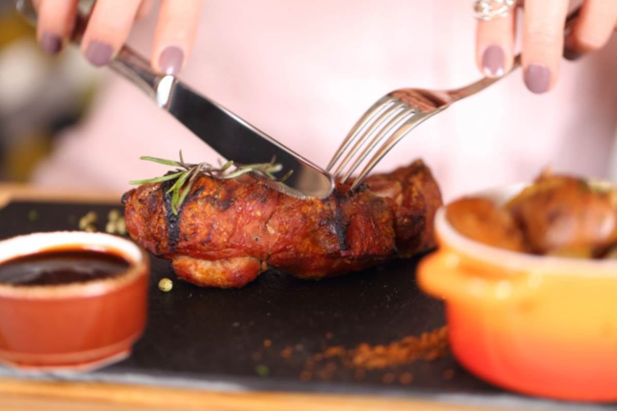 donna che taglia un filetto di carne