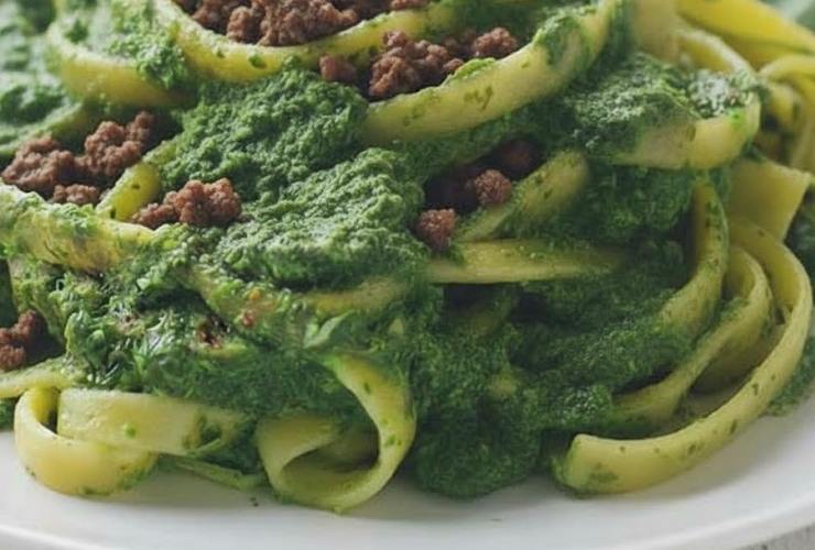 primo piano di tagliatelle con crema di spinaci e salsicce sbriciolate