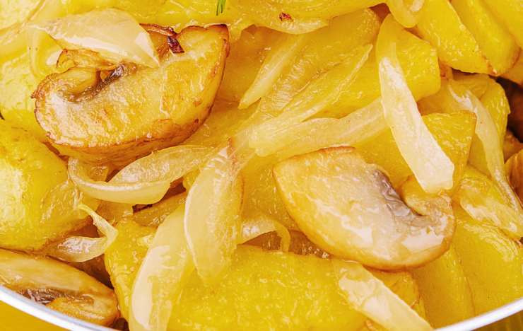 primo piano di patate e cipolle cotte in padella