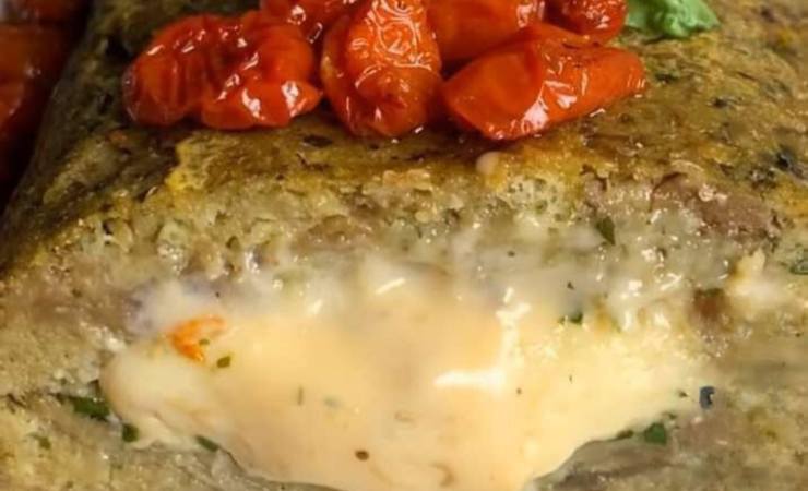 fetta di polpettone di melanzane con ripieno di formaggio e pomodorini