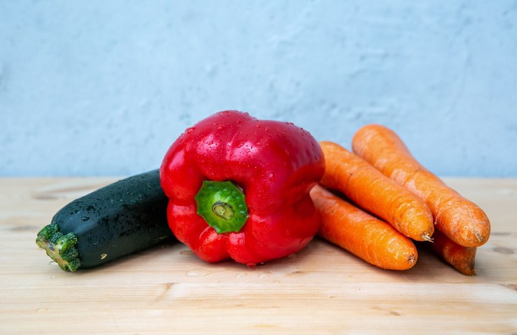 Una zucchina con un peperone e quattro carote