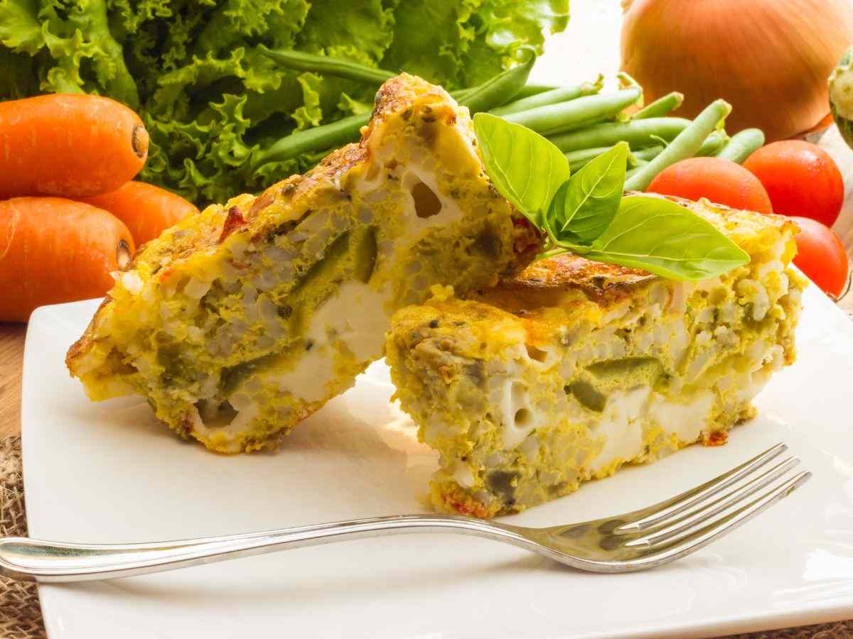 una torta salata con broccoli e carote dietro