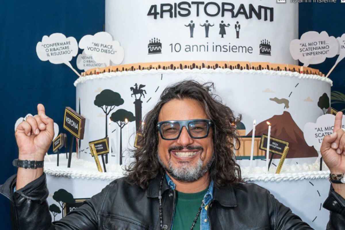 alessandro borghese che sorride e dietro di lui una torta per festeggiare i 10 anni di 4 ristoranti