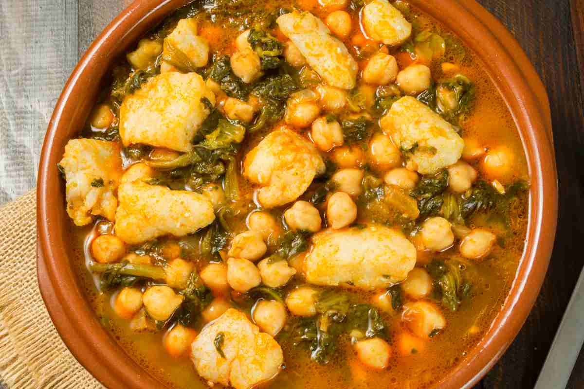 una terrina con baccalà, ceci e patate in umido vista da vicino dall'alto