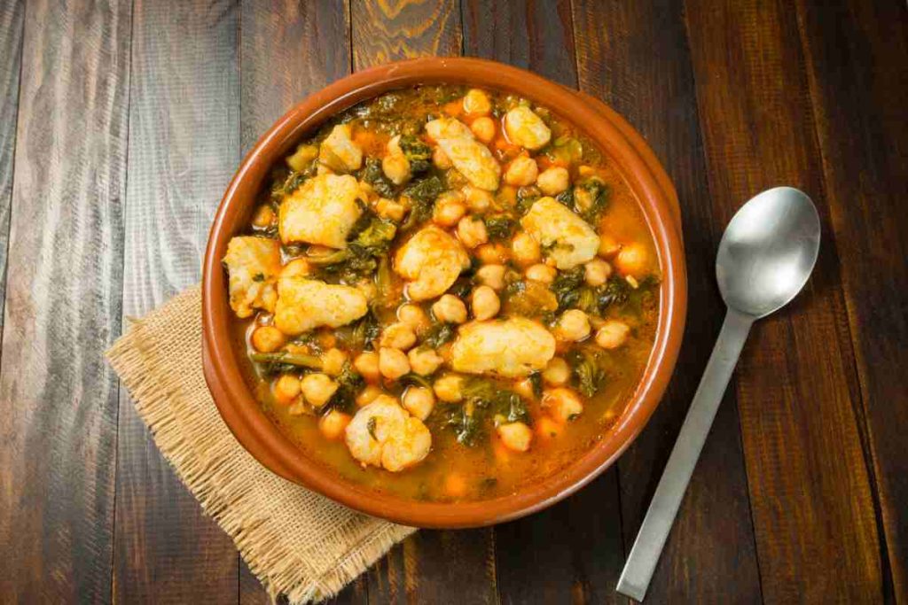 una terrina con baccalà, ceci e patate in umido vista dall'alto