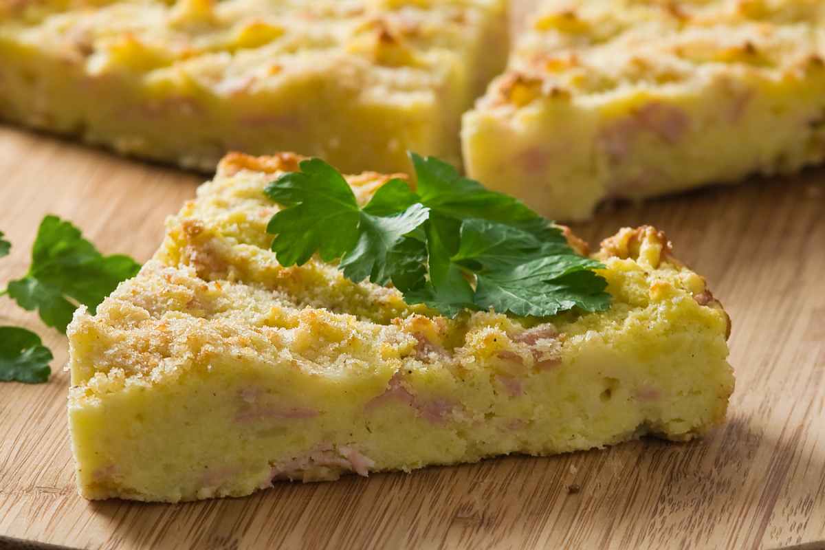 Gateau di patate a spicchi su un tagliere di legno
