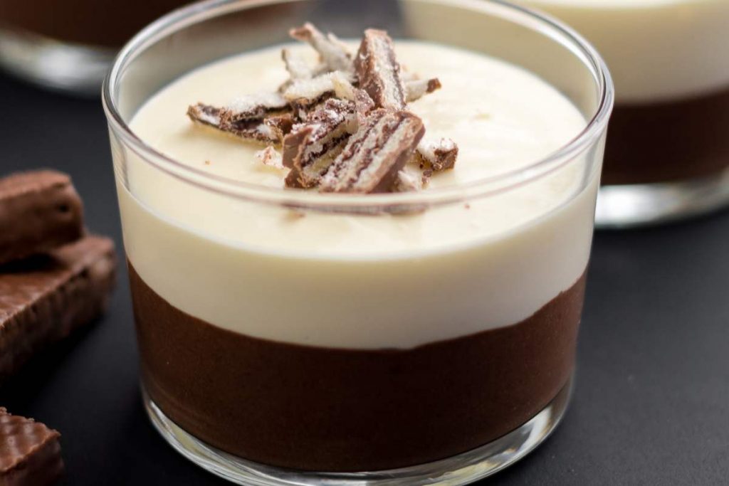 una coppa con la mousse ai due cioccolati decorata con wafer sbriciolati