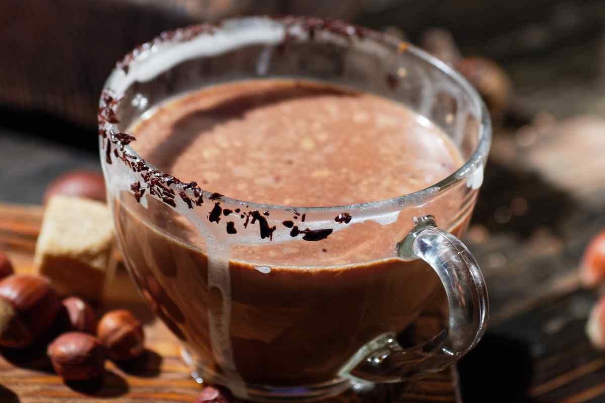 tazza con la nocciolata calda e scaglie di cioccolato sul bordo