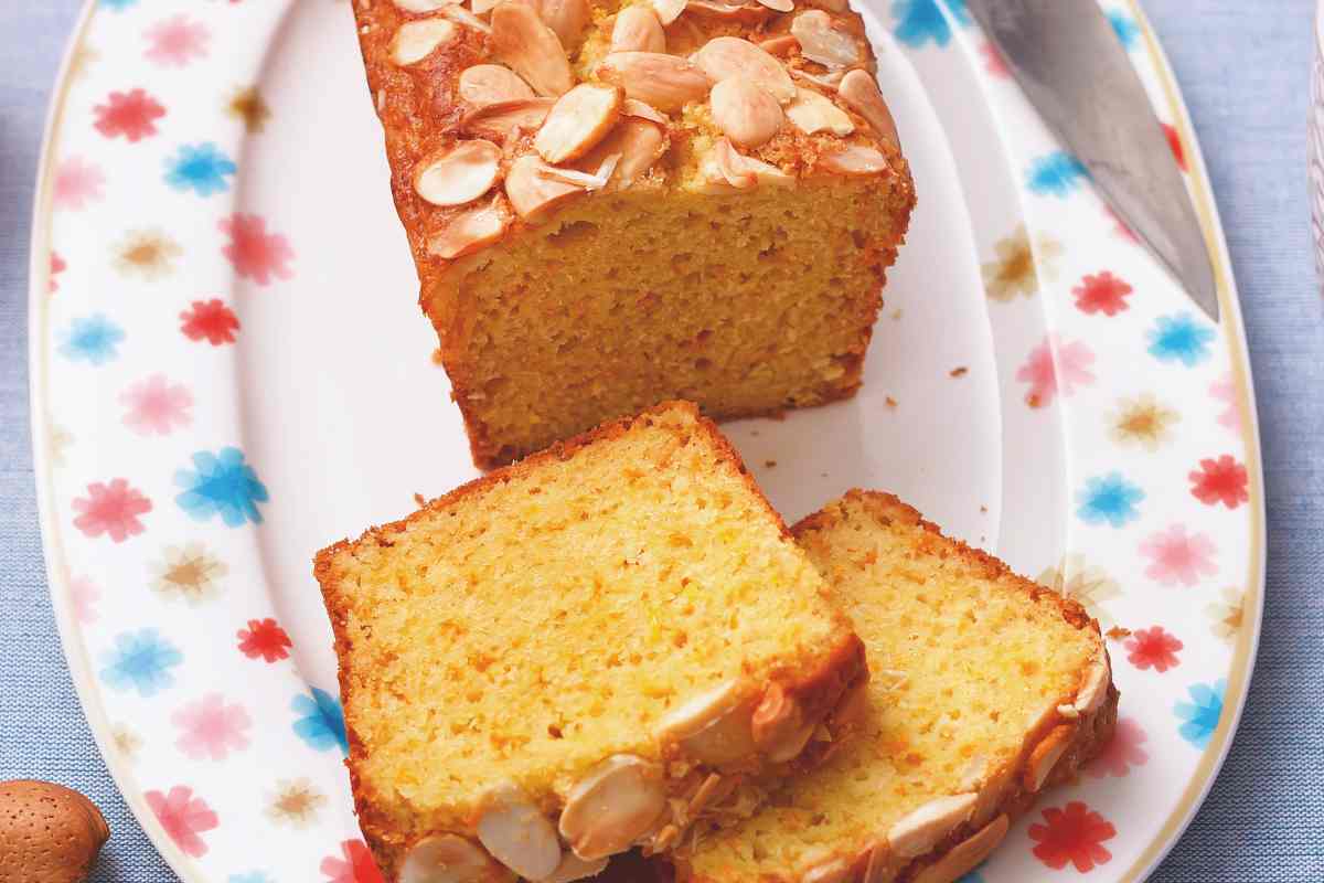 vassoio con dentro un plumcake all'arancia e scaglie di mandorle in superficie