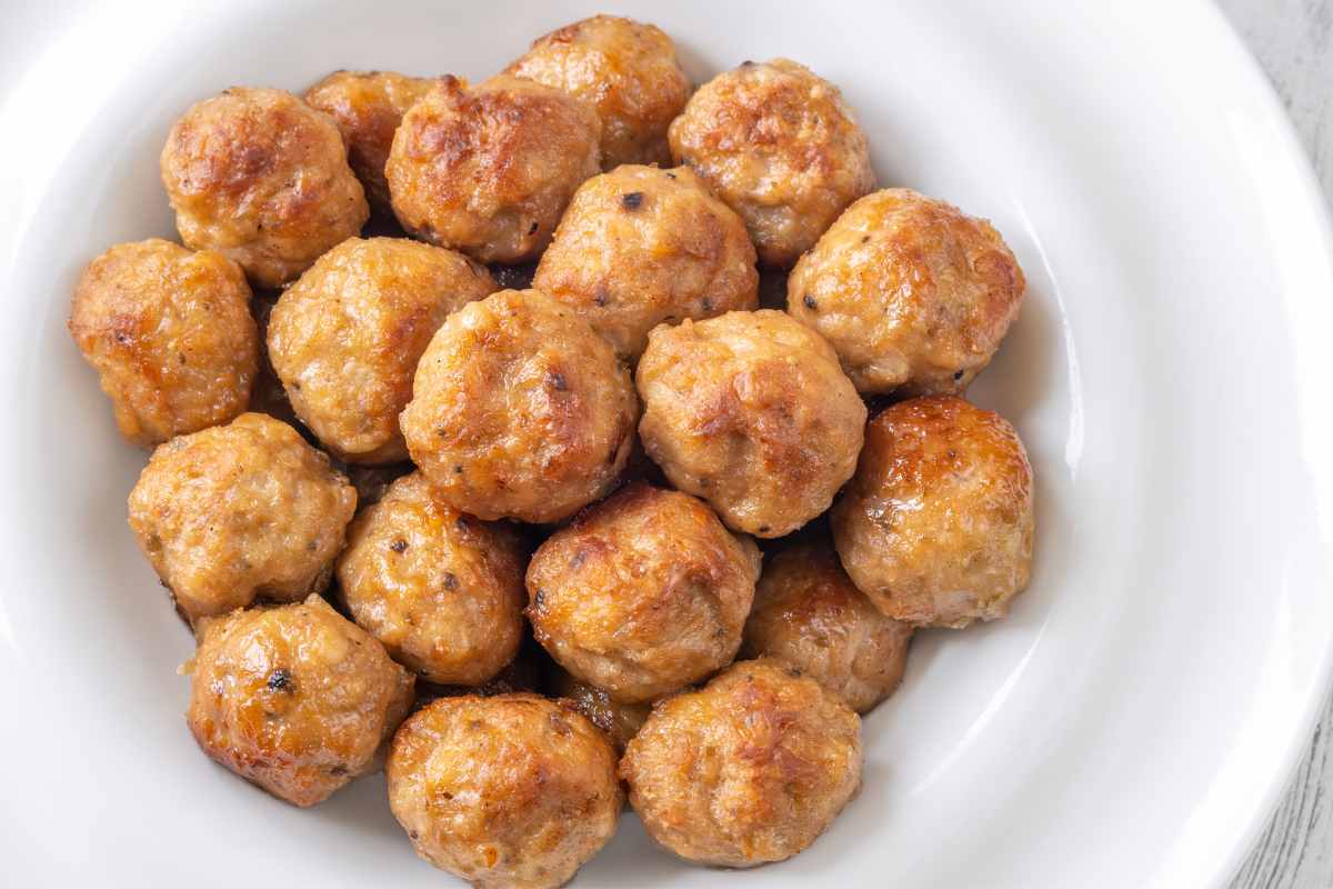 un piatto visto dall'alto contenente tante polpette di pollo e patate