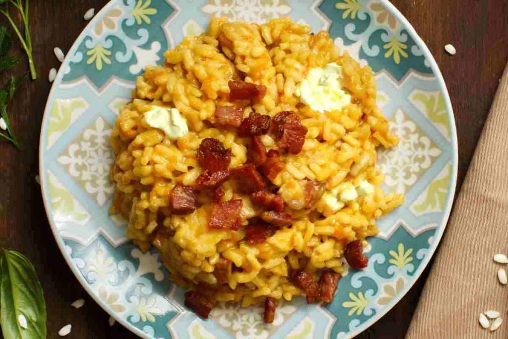 un piatto di risotto alla zucca con gorgonzola e guanciale croccante visto dall'alto