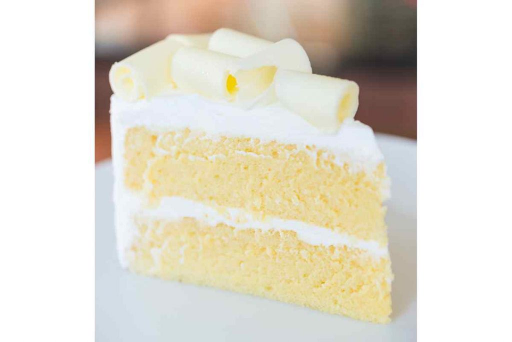 Fetta di torta al cioccolato bianco farcita di crema in un piatto