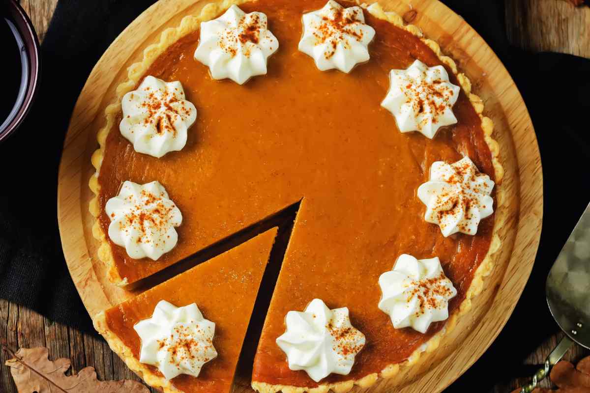 una torta di zucca decorata con ciuffi di panna montata vista dall'alto