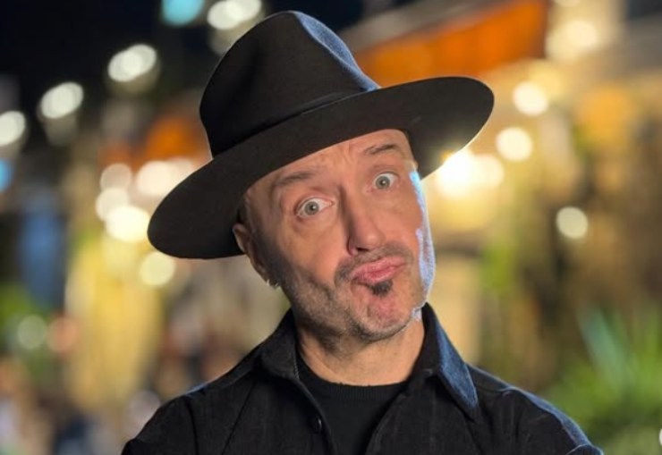 joe bastianich con il cappello in testa che fa una smorfia buffa